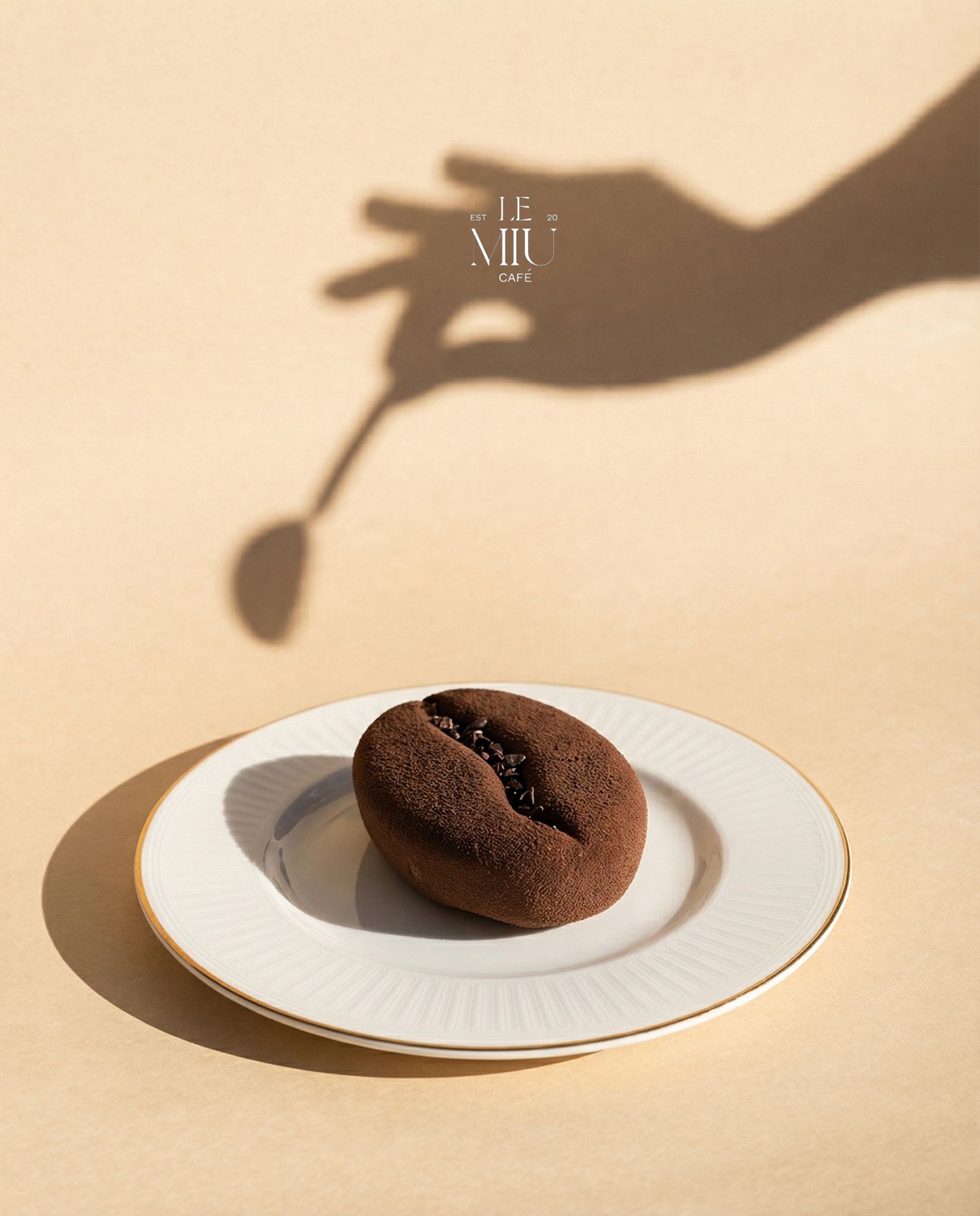 Signature chocolate cake shaped as a coffee bean on a gold-rimmed plate
